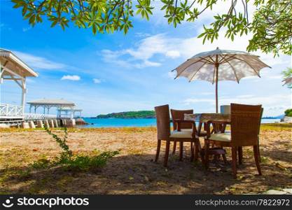 Chairs and table under umbrella Near the sea At the bright air. On of Weekend.
