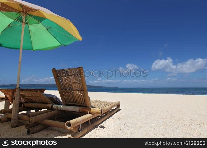 Chairs with parasol on beach. Relaxing couch chairs with parasol on white sandy beach at Philippines