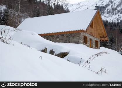 Chalet in winter. Chalet covered with snow in the French Alps