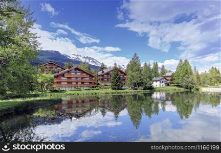 Chalets and lake at Crans-Montana by beautiful day, Valais, Switzerland. Crans-Montana, Valais, Switzerland