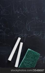 chalk and chalk eraser on the dirty blackboard