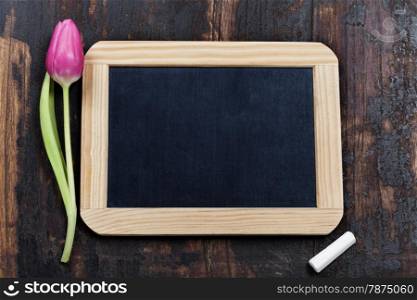chalk board and tulip on wooden background