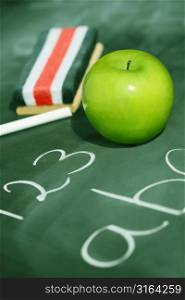Chalk board with eraser and apple