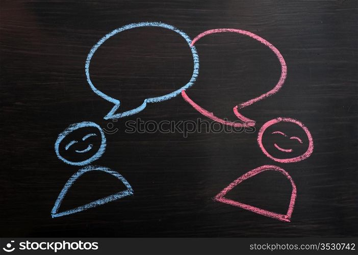 Chalk drawing of blank speech bubbles with human figures on a blackboard background