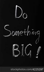 Chalk writing of Do something BIG on a blackboard
