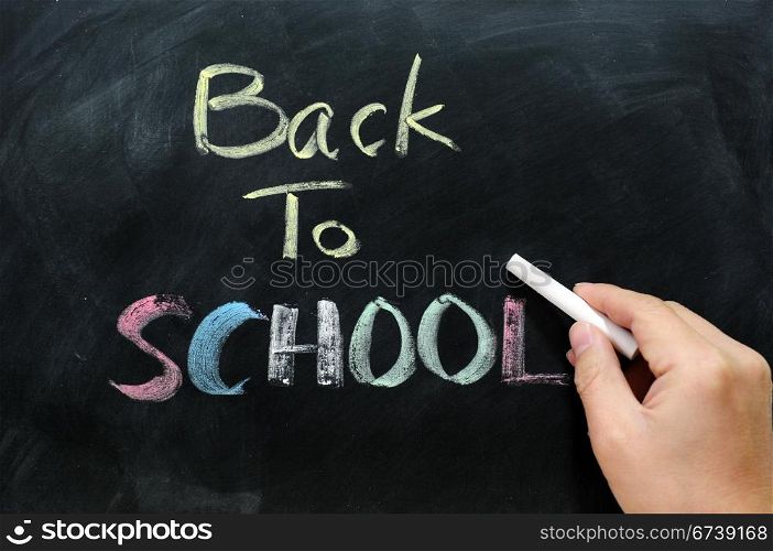 "Chalkboard Background with a handwriting of "back to school""