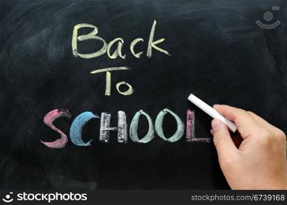 "Chalkboard Background with a handwriting of "back to school""