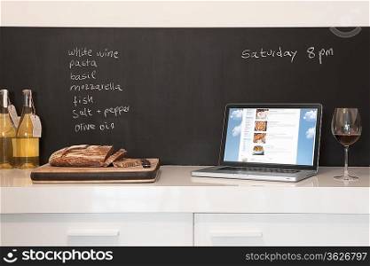 Chalkboard list with cut bread and laptop computer