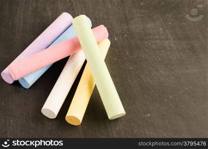 Chalks in a variety of colors arranged on a chalkboard background