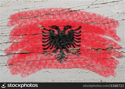Chalky albanian flag painted with color chalk on grunge wooden texture