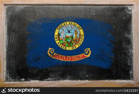 Chalky american state of idaho flag painted with color chalk on old blackboard