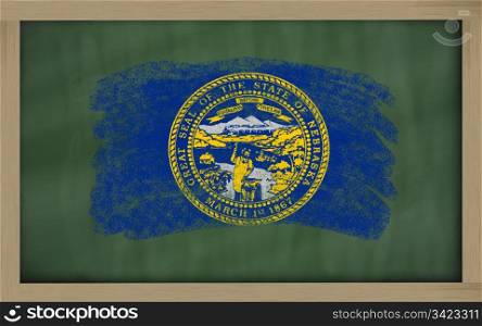 Chalky american state of nebraska flag painted with color chalk on old blackboard