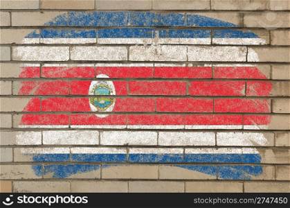 Chalky costa rica flag painted with color chalk on grunge old brick wall