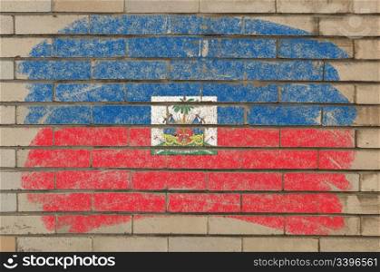 Chalky haitian flag painted with color chalk on grunge old brick wall
