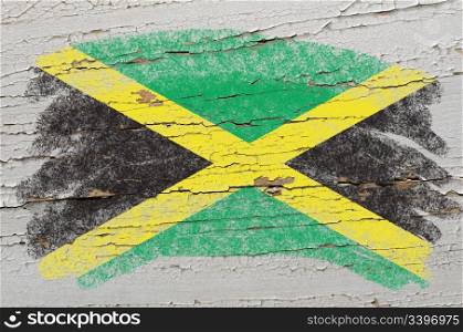 Chalky jamaican flag painted with color chalk on grunge wooden texture