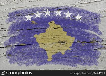 Chalky kosovo flag precisely painted with color chalk on grunge wooden texture