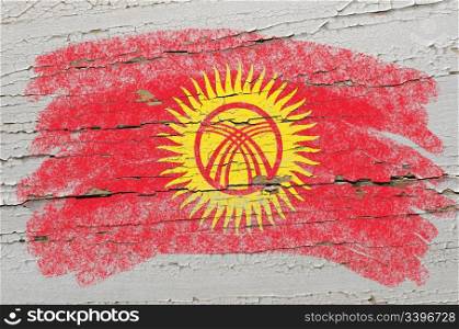 Chalky kyrghyzstan flag painted with color chalk on grunge wooden texture