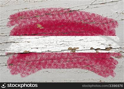 Chalky latvian flag painted with color chalk on grunge wooden texture