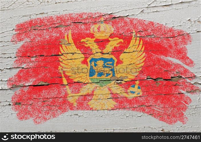 Chalky montenegrian flag painted with color chalk on grunge wooden texture