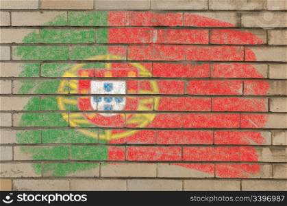 Chalky portugese flag painted with color chalk on grunge old brick wall
