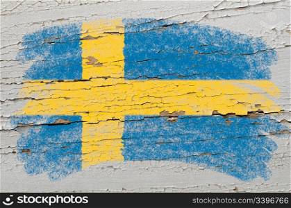 Chalky swedish flag painted with color chalk on grunge wooden texture