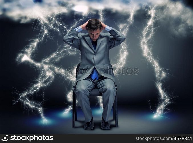 Challenge in business. Conceptual image of troubled businessman sitting under rain