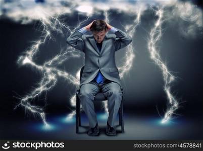 Challenge in business. Conceptual image of troubled businessman sitting under rain