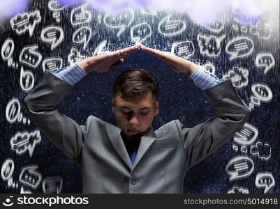 Challenge in business. Frustrated businessman protecting his head with arms