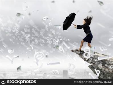 Challenge in business. Young determined businesswoman walking against strong wind