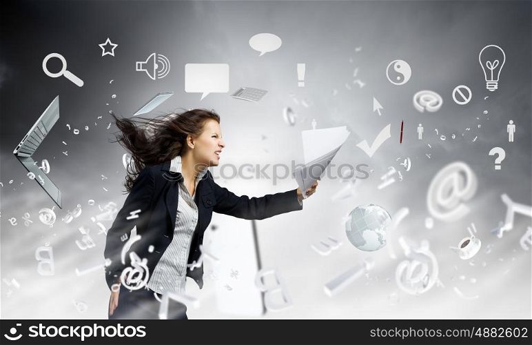 Challenge in business. Young determined businesswoman walking against strong wind