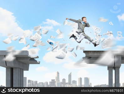 Challenge overcoming. Young businessman jumping over bridge gap. Risking in business