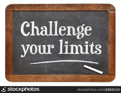 Challenge your limits - white chalk text on a vintage slate blackboard