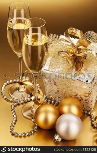 champagne and christmas present. two glasses of champagne with christmas present and christmas balls