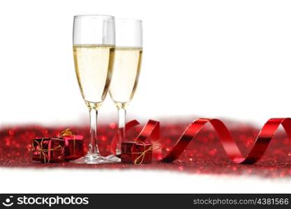 Champagne and holiday gifts on red glitter background
