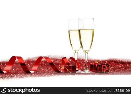 Champagne and holiday gifts on red glitter background
