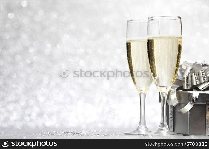 Champagne and present on silver bokeh background