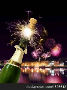 Champagne bottle cork popping with sparkling New Year fireworks