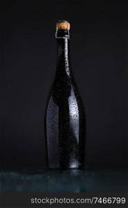 Champagne bottle on a wet dark surface