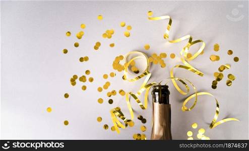 champagne bottle with golden confetti streamers white background