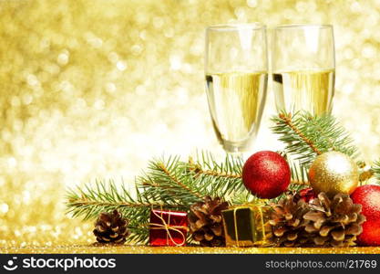 Champagne, fir tree, christmas decor and gifts on golden background