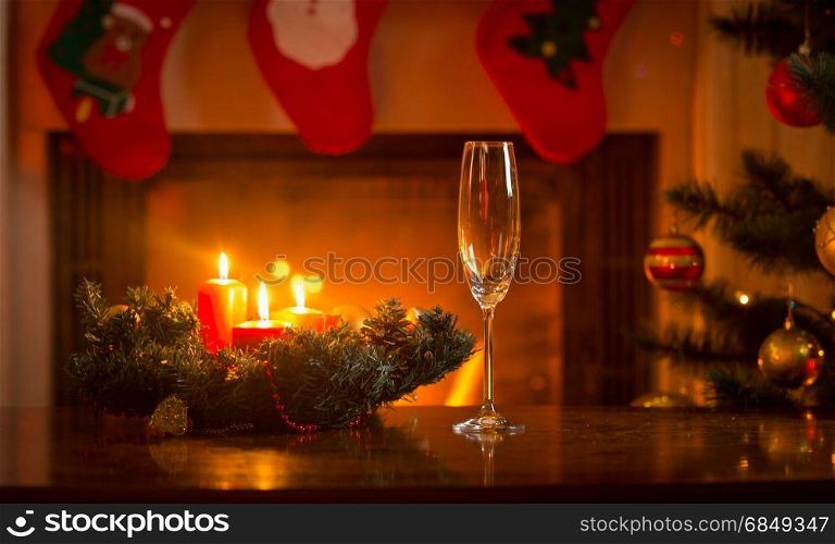 Champagne flute on Christmas dinner table in front of burning fireplace