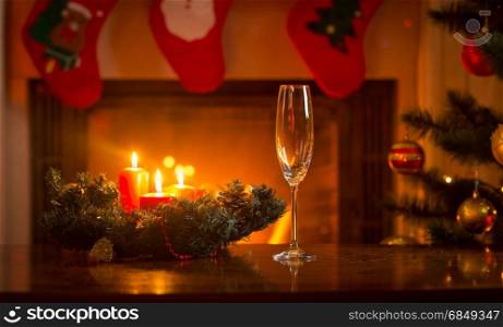 Champagne flute on Christmas dinner table in front of burning fireplace
