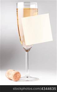champagne glass with blank sticky note and cork