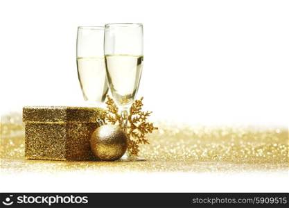 Champagne glasses and christmas decor on glitters with white copy space
