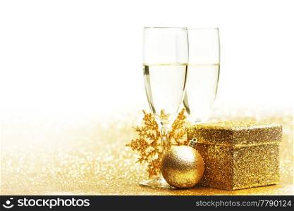 Champagne glasses and christmas decor on glitters with white copy space