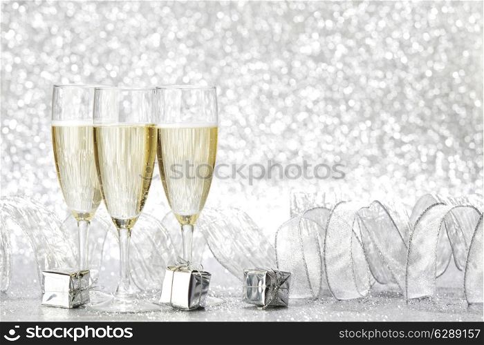 Champagne glasses and christmas decoration on silver bokeh background
