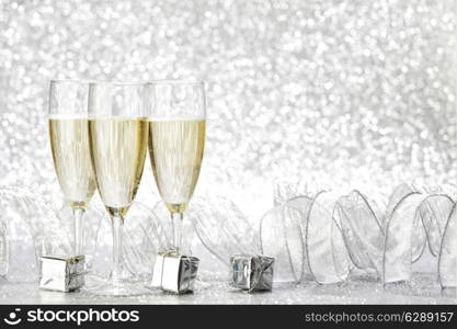 Champagne glasses and christmas decoration on silver bokeh background