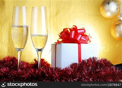 Champagne glasses and gift box on celebratory table