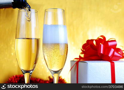 Champagne glasses and gift box on celebratory table