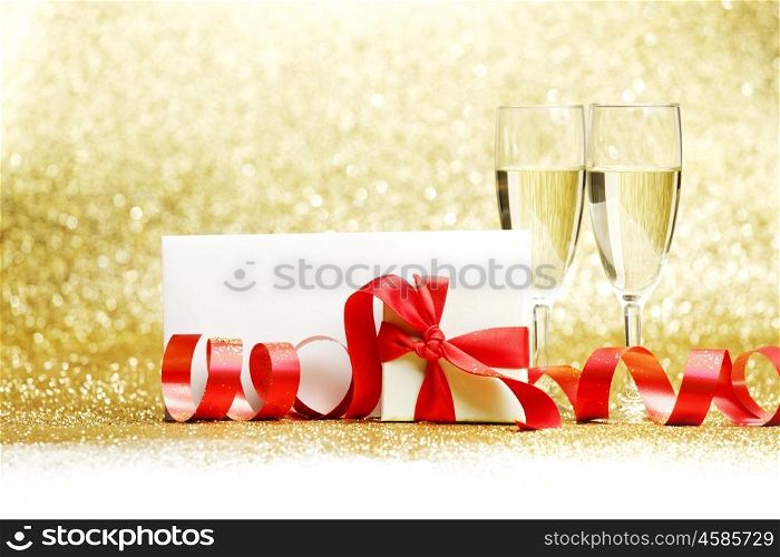 Champagne glasses and gift on glitters with white copy space